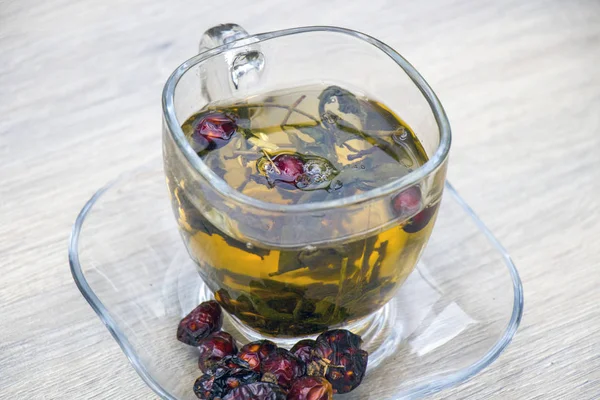 Gri ahşap zemin üzerine yeşil çay bardağı