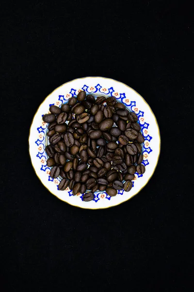 Kubek pełen ziaren kawy na drewnianym stole — Zdjęcie stockowe