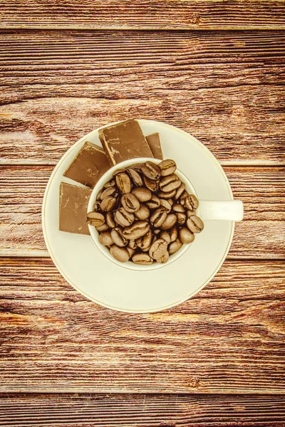 Odun masada kahve çekirdekleri dolu fincan