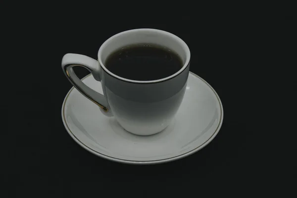 关闭黑色热咖啡杯，并在黑色木桌上用拿铁艺术泡沫吸烟。 — 图库照片