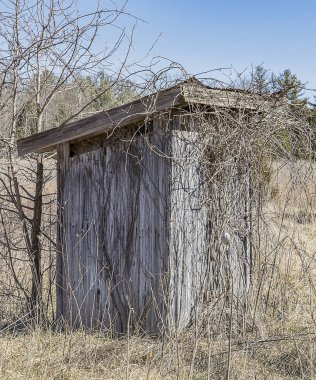 Kırsal bir alanda yaşlanarak terk edilmiş bir tuvalet. 