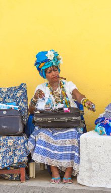 Havana, Küba-Ekim 8, 2016. Küba yerli, ilginç, eski Bayan geleneksel giysilerle sokakta onu her zamanki yaşam tarzı 8 Ekim 2016 Havana şehrin eski kesiminde oturan puro ile giyinmiş.