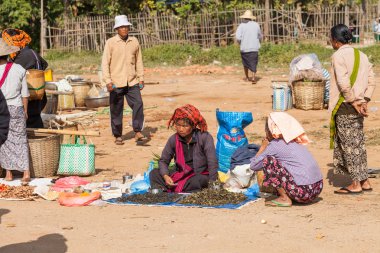 Inle Gölü, Myanmar-Aralık 20, 2015. Mal ve alıcı ne pazar market yerel Ywama Köyü, alanı çevreleyen tepe kabileleri satmak ve Myanmar Inle Gölü 20 Aralık 2015 satın nereden satın almak seyir tepe kabile kadın satıyor.