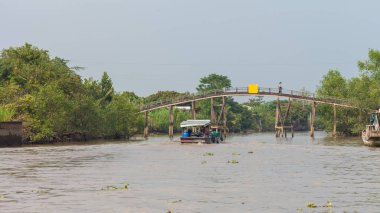 Mekong Delta, Vietnam-Aralık 10, 2013. Mekong Nehri üzerinde ahşap ayağı köprü üzerinde 10 Aralık 2013 Mekong Delta Güney Vietnam'daki nehir kıyısında seatlements arasında bağlantıdır.