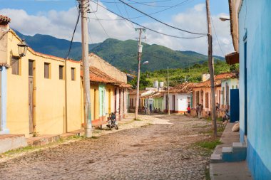 Trinidad, Küba-14 Ekim 2016. Orta Küba Trinidad kasabasında arka planda renkli tarihi sömürge tarzı binalar ve dağlar ile sokak görünümü.