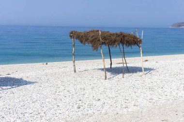 Sahilde saman gölgeliği. Borsh Arnavutluk