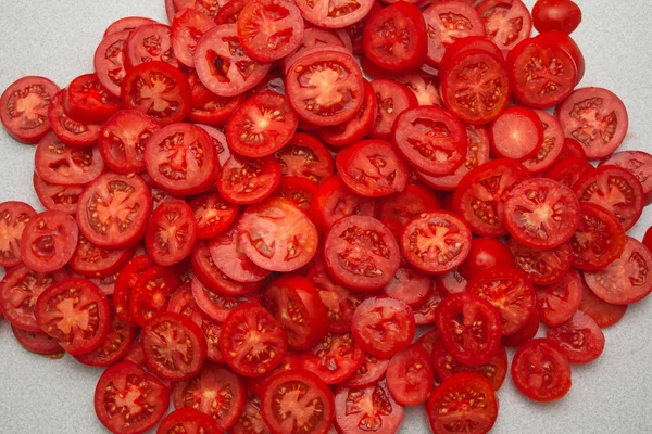 a lot of sliced sliced tomatoes on a gray background