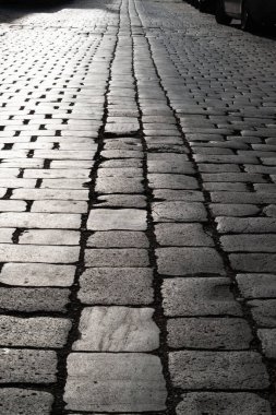 Arka planda taşlar var. Uzağa uzanan asfalt bir yol. yakın plan