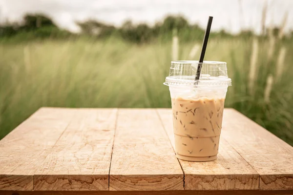 Iced blended frappucino in plastic cup on wood table. Iced coffe — Stock Photo, Image