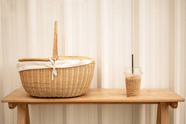 Iced blended frappucino in plastic cup and picnic basket on wood — Stock Photo, Image