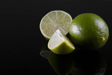 taze bütün ve siyah arka plan üzerinde izole kesilmiş kireç. biraz odaklanmamış arka plan