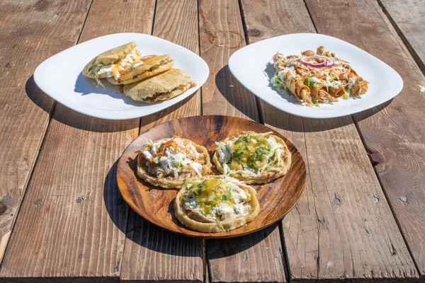 variety of Mexican food dishes. sopes, tacos, gorditas stuffed.