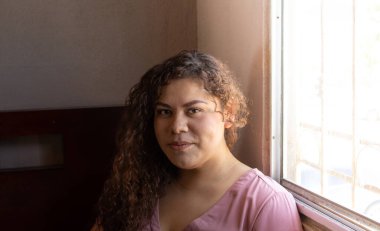 Latin görünümlü kıvırcık saçlı Meksikalı kadın portresi.