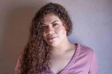 Yatağında kıvırcık saçlı, Latin görünümlü tombul Meksikalı kadın.