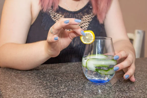 酒保女士用黄瓜 柠檬和伏特加准备爽口的鸡尾酒 — 图库照片