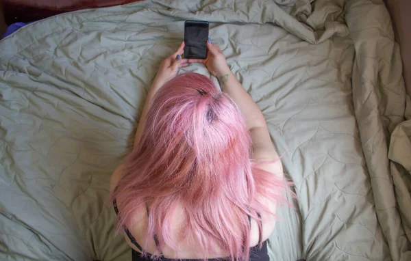 Mujer Pelo Rosa Acostada Cama Usando Teléfono Celular —  Fotos de Stock