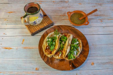 Barbacoalı Meksika tacoları, yeşil sos ve Cafe de la olla.