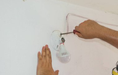 Elektrikçi hasarlı ampulü tamir ediyor. elektrik onarımı