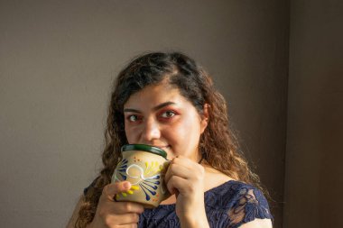 Güzel Meksikalı kadın, Meksika fincanından kahve içiyor.