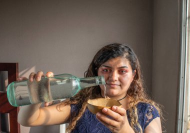 Meksikalı kadın zanaatkar bardağında tekila ya da mezcal servis ediyor.