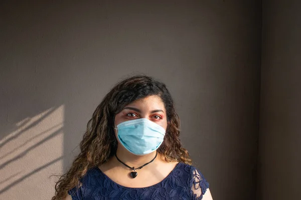 COVID 19 'dan korumak için yüz maskesi takan Latin bir kadın.