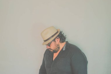 Sombrero ve güneş gözlüğü takan zarif bir Meksikalı. Model bir tavırla.