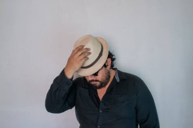 Sombrero ve güneş gözlüğü takan zarif bir Meksikalı. Model bir tavırla.