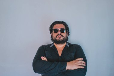 Kameraya bakarken gözlük takan sakallı yakışıklı İspanyol adam.