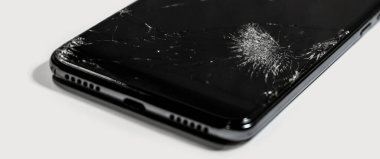 Mobil cihazların tamiri. Siyah akıllı telefonun dokunmatik ekranı kırılmış. Yakın çekim hasarı.