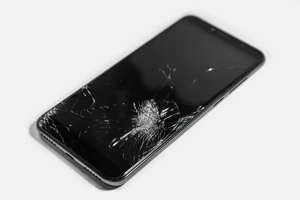 Mobil cihazların tamiri. Siyah akıllı telefonun dokunmatik ekranı kırılmış. Yakın çekim hasarı.