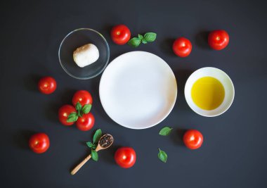 Caprese salatası malzemeler boş plaka koyu arka plan üzerinde çevresinde