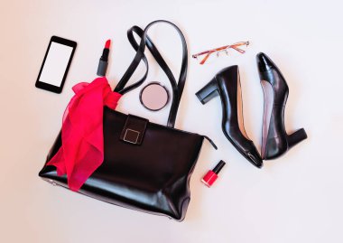 Siyah deri çanta, siyah ayakkabılar, smartphone, gözlük ve kozmetik üstten görünüm