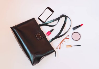 Moda kavramı: flatlay ile akıllı telefon, gözlük ve kozmetik pastel arka plan üzerinde siyah deri çanta