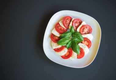 Mozzarella peyniri, domates ve yeşil Fesleğenli Caprese salatası. Üstten görünüm, kopya alanı.
