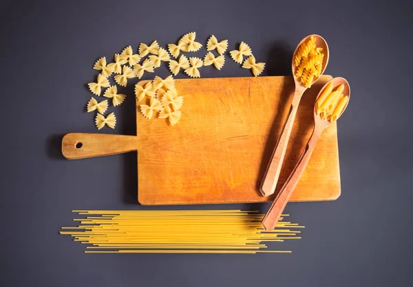 Schneidebrett Und Rohe Pasta Auf Dunklem Hintergrund — Stockfoto