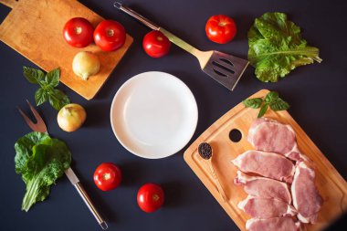 Kopya alanı, taze Çiğ domuz eti ve sebze koyu arka plan üzerinde beyaz tabak. Üstten görünüm.