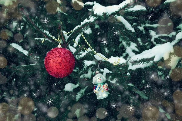 雪の冬の森の木の枝にぶら下がっている赤いクリスマス ボールと雪だるまクリスマス装飾 — ストック写真