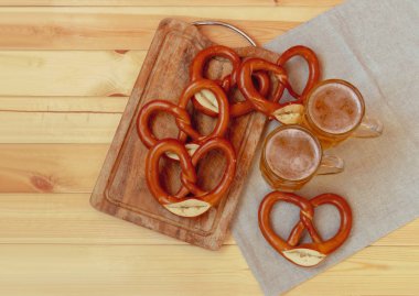 Bira bardağı ve ahşap masa üzerinde taze pişmiş çubuk kraker. Kopya alanı ile üstten görünüm.