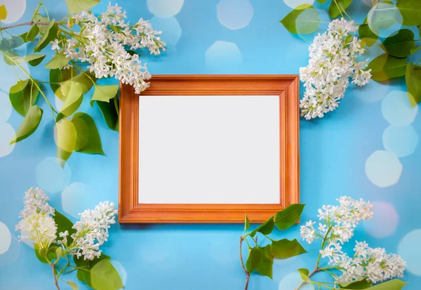 Ahşap çerçeve ve mavi zemin üzerine beyaz leylak çiçekler. 