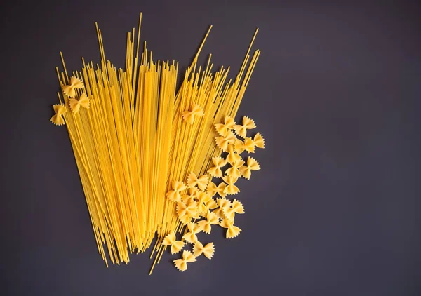 Rohe Nudelspaghetti Und Farfalle Auf Dunklem Hintergrund Ansicht Von Oben — Stockfoto