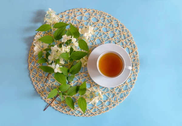 Taza de té verde y flores de jazmín sobre fondo azul . —  Fotos de Stock