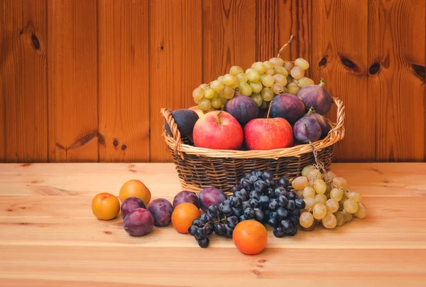 Cesta de mimbre con frutas frescas sobre fondo de madera. Enfoque selectivo . —  Fotos de Stock