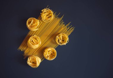 Karanlık arka planda ham makarna Fettuccine ve spagetti.