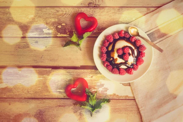 Twee rode hartjes met muntblaadjes en zelfgemaakt Italiaans dessert Panna Cotta met verse frambozen en chocolade stroop. — Stockfoto