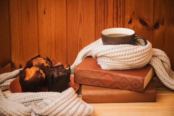 Taza de café caliente, magdalenas, pila de libros y bufanda en la mesa de madera . —  Fotos de Stock
