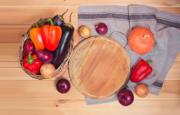 Tabla de cortar con verduras frescas y servilleta sobre fondo de madera . —  Fotos de Stock