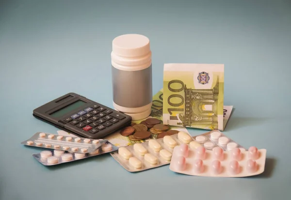 Tabletten en pillen in blisters en in fles, geld en Calculator. Selectieve focus. — Stockfoto
