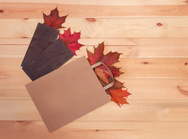 Colorful autumn leaves in paper bags. Sale and shopping concept.