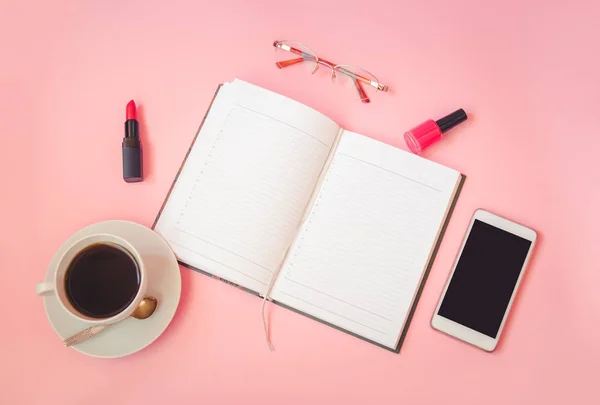 Φλιτζάνι καφέ, γυαλιά, κραγιόν, βερνίκι νυχιών, smartphone και ημερολόγιο σε ροζ φόντο — Φωτογραφία Αρχείου