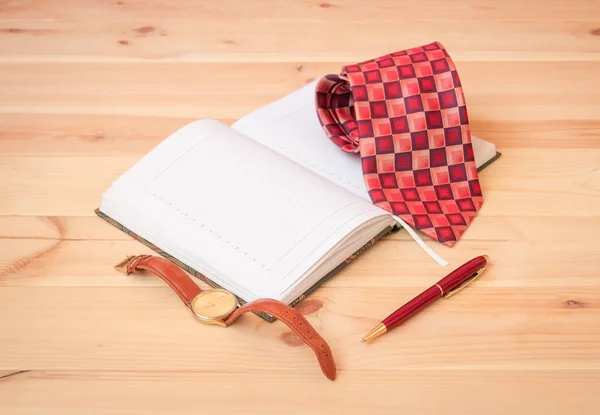 Rullslips, dagbok, klocka och penna på träbord. Selektivt fokus. — Stockfoto